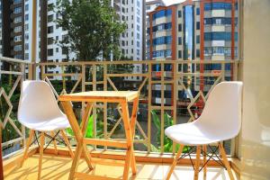a table and two chairs on a balcony with a view at Large Studio In Heart of Westlands in Nairobi