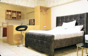 a bedroom with a large bed and a kitchen at Large Studio In Heart of Westlands in Nairobi