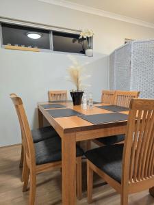a dining room table with two chairs and a table and chairsktop at Stylish 2-Bedroom Apartment in Maddington, 15 Minutes from Perth Airport in Perth