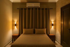 ein Schlafzimmer mit einem großen Bett und zwei Nachttischen in der Unterkunft Villa Kaba Hippodrome Électricité solaire 24h24 in Bamako