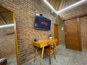 a sign on a brick wall with a wooden table at Kamanaya Ubud in Ubud