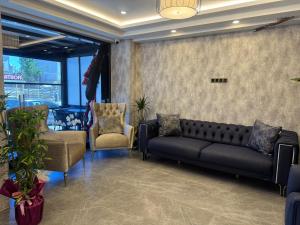 a waiting room with a couch and two chairs at Gnc Airport Hotel in Arnavutköy