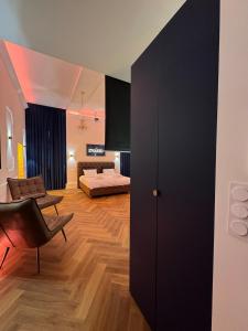 ein Wohnzimmer mit einem schwarzen Schrank und ein Schlafzimmer in der Unterkunft Evasio Suite in Sedan