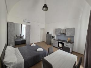 a bedroom with a bed and a table and a kitchen at Mammarusina in Brindisi
