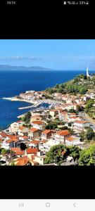 a view of a town with the ocean and houses at Apartman Karmela in Podgora