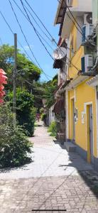 an empty street with a yellow building on the side at Quarto de vila na Urca in Rio de Janeiro