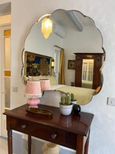 a bedroom with a bed and a table with a mirror at Charming 1-bed place in historic, vibrant Hamrun near Valletta in Hamrun