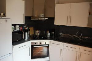 a kitchen with white cabinets and a white oven at Saint-Denis de La Réunion - Maison in Arras +4 photos