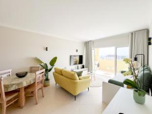 ein Wohnzimmer mit einem gelben Stuhl und einem Tisch in der Unterkunft Apartment Vila Marachique Sunlime Stay in Alvor