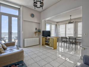 a living room with a couch and a television and a table at Arcachon Pereire - T2 front de mer avec terrasse et parking, accès direct plage - FR-1-433-24 in Arcachon