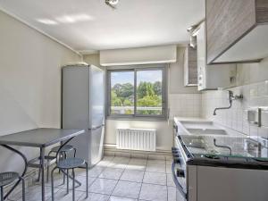 a kitchen with a table and chairs and a window at Arcachon Pereire - T2 front de mer avec terrasse et parking, accès direct plage - FR-1-433-24 in Arcachon