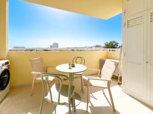 einen kleinen Tisch und Stühle auf einem Balkon mit Aussicht in der Unterkunft Apartment Vila Marachique Sunlime Stay in Alvor