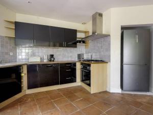 a kitchen with black cabinets and a stainless steel refrigerator at Villa Familiale près du Moulleau et Plage des Arbousiers avec Grand Jardin et Terrasse - FR-1-433-18 in Arcachon +16 photos