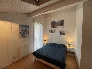 1 dormitorio con 1 cama, 2 mesas y una ventana en T3 Duplex avec Piscine, Tennis, Parking et Terrasse à Soustons - FR-1-379-78, en Soustons