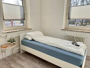 Un dormitorio pequeño con una cama y dos ventanas. en Arbeiter - Lounge 1, en Salzgitter
