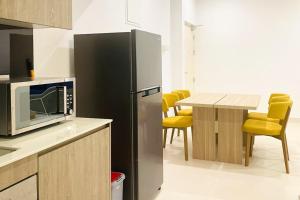 a kitchen with a refrigerator and a table with yellow chairs at Luxury Cozy Apartment - Fairway Galle in Galle
