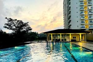 a large swimming pool next to a tall building at Luxury Cozy Apartment - Fairway Galle in Galle