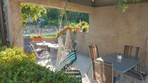 a patio with tables and chairs in a garden at Apartment Di Novi Vinodolski in Novi Vinodolski
