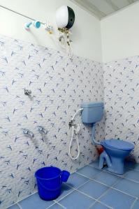 a bathroom with a blue toilet and a shower at Alleppey Haven 6BR Whole House by Backwater in Alleppey +18 photos