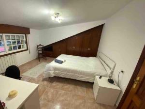 ビーゴにあるÁtico con vistas y aparcamiento gratuitoのベッドルーム1室(ベッド1台、ランプ付きデスク付)