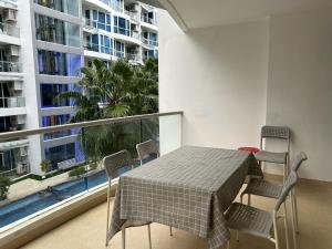 Un balcón con mesa y sillas y una gran ventana. en Grand Avenue Residence condominium, en Pattaya central