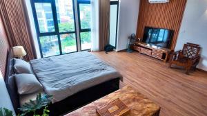 Una sala de estar con una cama y un televisor. en Midtown home, en Hanói