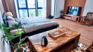 1 dormitorio con 1 cama y 1 mesa con mesa de centro Sidx Sidx en Midtown home, en Hanói