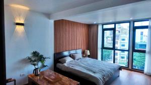 Un dormitorio con una cama y una ventana grande en Midtown home, en Hanói