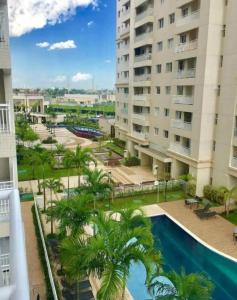an apartment building with a swimming pool and palm trees at COP 30 Apartamento Luxo - 3 Quartos, Piscina, Academia, Area de Lazer in Belém