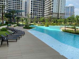 a swimming pool in a city with chairs and buildings at HOMESTAY ADORA in Long Bình