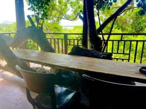 a wooden bench sitting next to a tree at Lake Wind Resort & Restaurant in Polgahawelana