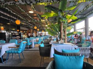 een eetkamer met blauwe stoelen en tafels en mensen bij Azimuth Luxury in Constanţa