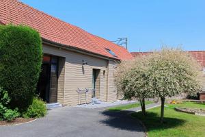 a building with a tree in front of it at Les Chambres de Saint Hilaire in Saint-Hilaire-Cottes