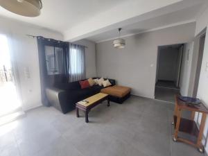a living room with a couch and a table at Apartment for rent in Néa Kíos