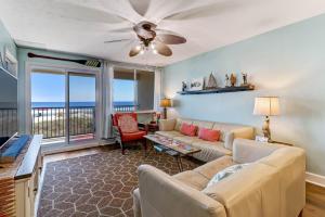 a living room with a couch and a ceiling fan at Condo w Google Mini Home in Fernandina Beach