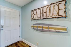 a bedroom with a surfboard on the wall at Condo w Google Mini Home in Fernandina Beach
