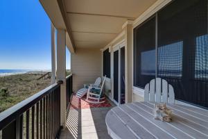a porch with a table and chairs and the beach at Condo w Google Mini Home in Fernandina Beach