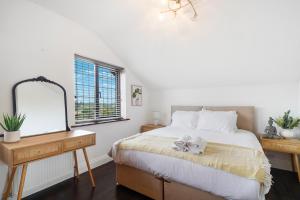 a bedroom with a bed with a dresser and a mirror at 2 King 4 Singles 2 Sofa Beds Driveway Parking x 3 Private Garden Decking in Hillingdon