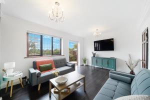 ヒリンドンにある2Bedroom 2 King4 Single 2Sofa Beds Parking x3 Garden & Patioのソファ2つとテレビのあるリビングルーム