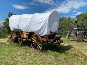 a covered wagon sitting in a field with a sign at O.k. Corral in Misano Adriatico