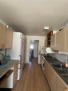 FårösundにあるFärösund Sommarの白い家電製品が備わるウッドフロアの空のキッチン +10枚の写真