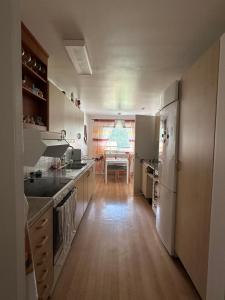 a kitchen with white appliances and a wooden floor at Färösund Sommar in Fårösund