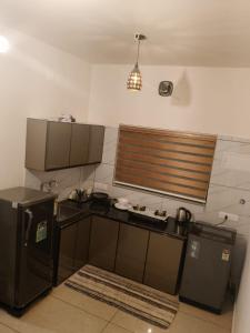 eine Küche mit einem schwarzen Kühlschrank und einer Spüle in der Unterkunft 88 STAY INN Edappally in Ernakulam + 9 Fotos