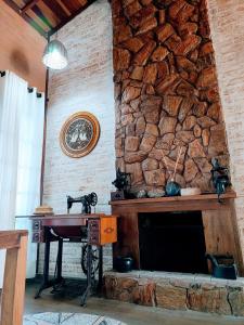 a stone wall with a table and a sewing machine at Casa Recanto Beija Flor, Monte Verde in Monte Verde
