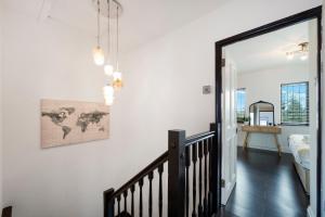 a hallway with white walls and a staircase with a world map on the wall at 2 King 4 Singles 2 Sofa Beds Driveway Parking x 3 Private Garden Decking in Hillingdon