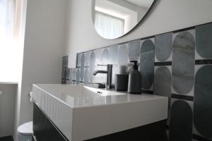 a bathroom with a sink and a mirror at La Corte dei Mercanti by Stresahome - Centro Storico in Stresa +87 photos