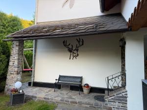 Un banco en una pared con una cabeza de ciervo encima. en Haus Leiner, 