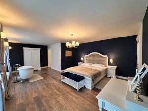 a bedroom with a bed and a bathroom with a tub at Forest House Retreat in Curtea de Argeş