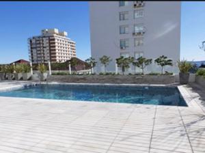 a swimming pool in front of a tall building at LUX TOWER Punta del Este Port in Punta del Este