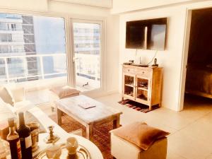 a living room with a large window and a table at LUX TOWER Punta del Este Port in Punta del Este